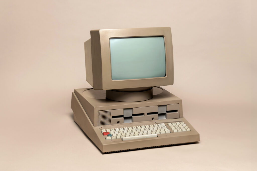 old beige personal computer representing vintage computing technology on a plain background